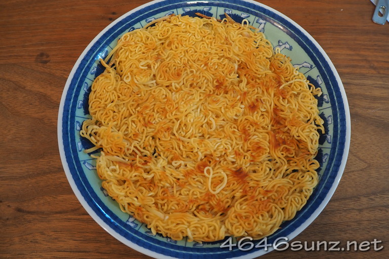 野菜たっぷりあんかけラーメンの焼きあがっためんをお皿に移した写真